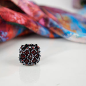 Close-up of dark red handmade scarf ring, with an Orange Bouquet 100% silk Italian scarf.